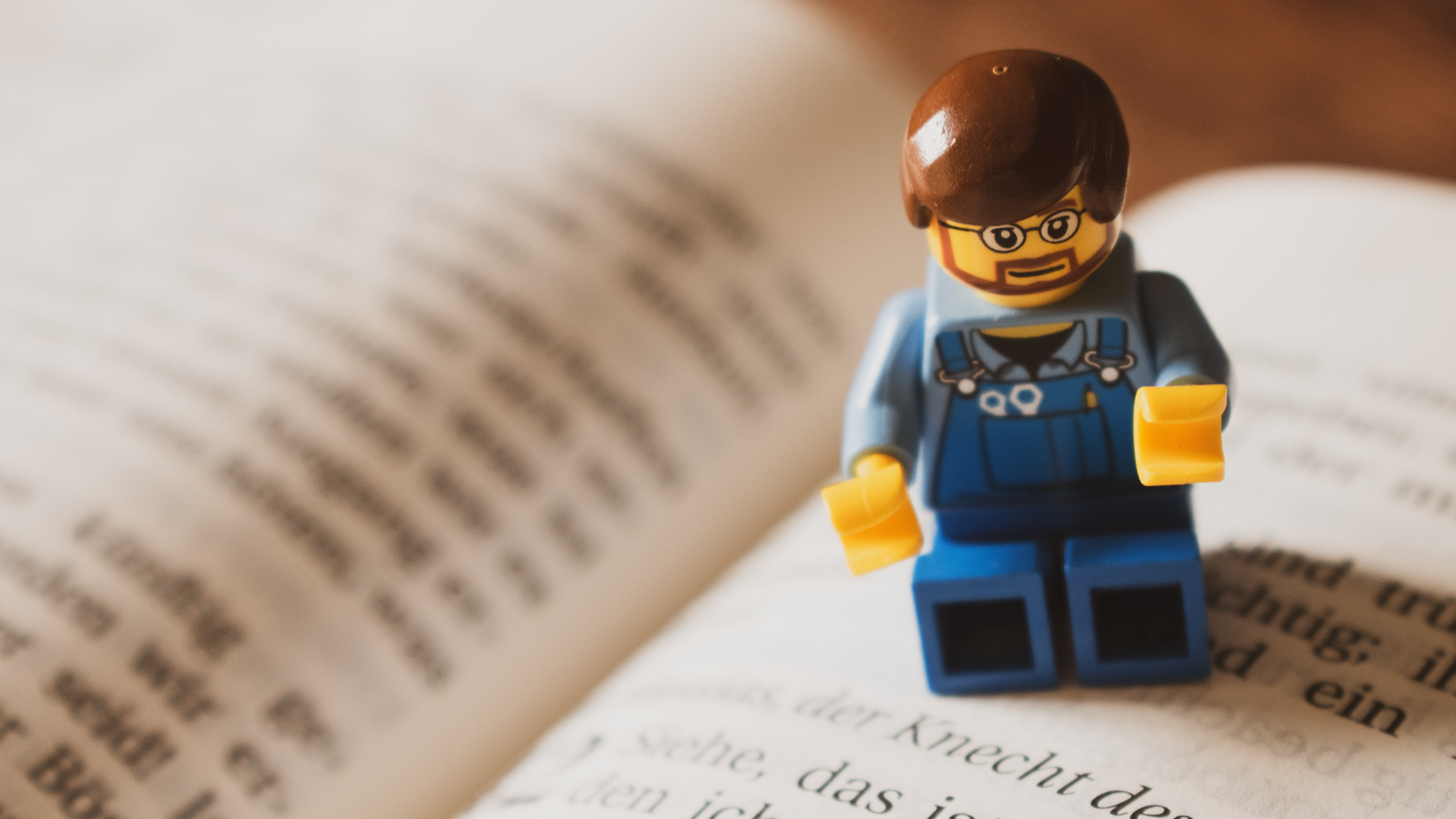 A lego character reading a page from a book