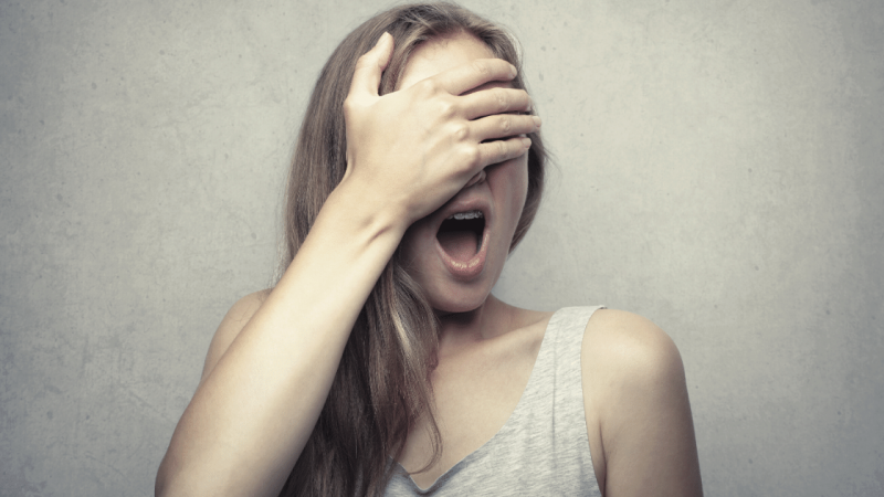 Woman covering face in fear of feedback