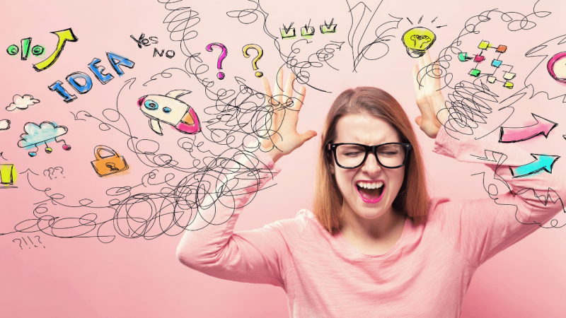 A woman clutching her head in stress because she's trying to write faster when she should be focusing on other things