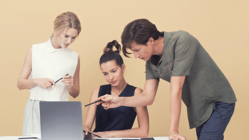 Woman getting feedback from two people at a laptop